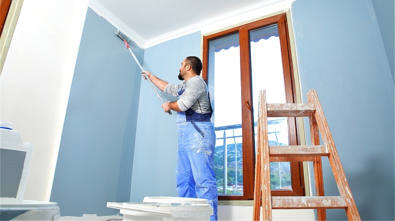 Person painting wall blue