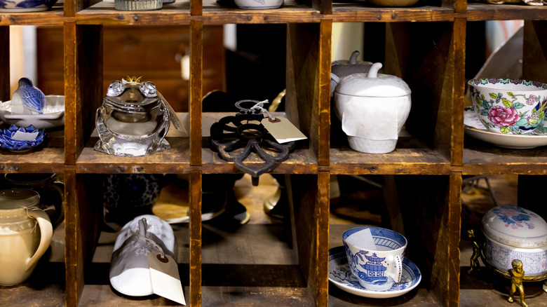 Wood shelves display vintage items in a thrift store.