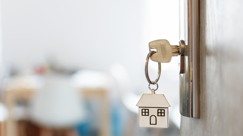 Key with house keychain in door of house/apartment