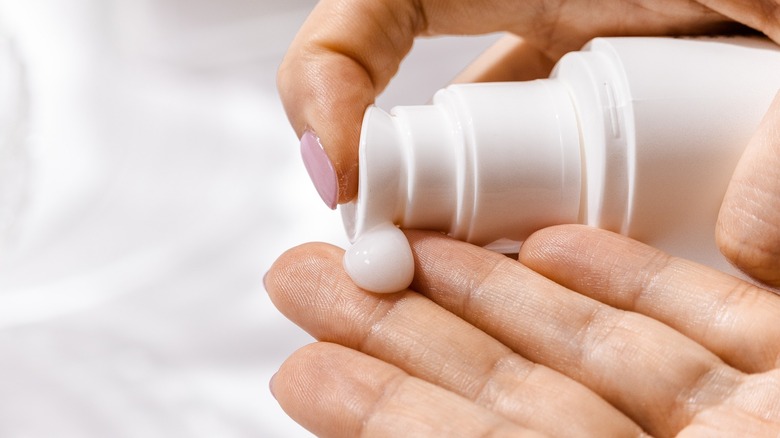 Woman applying shampoo to hand