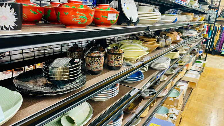Aisle of bowls and dishware on shelves in a thrift store