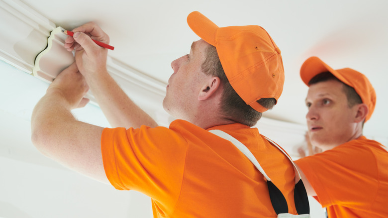 two contractors installing coving in a home