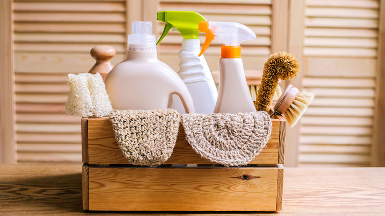 cleaning supplies in a wood basket on a table