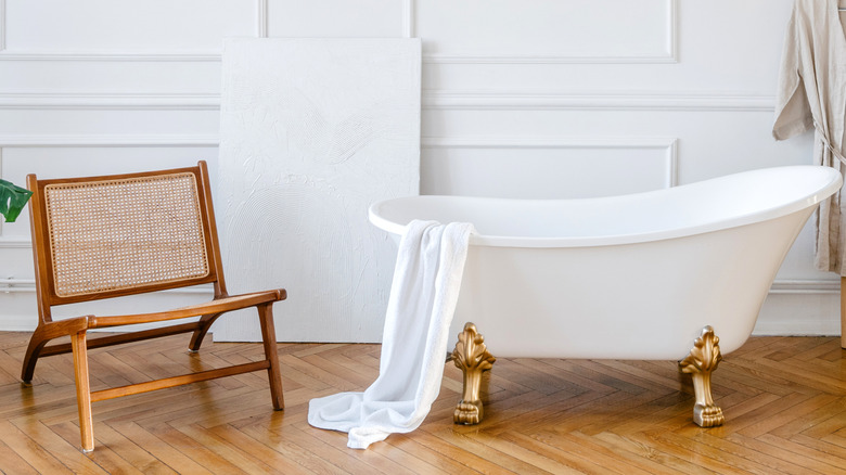 Wooden chair next to bathtub