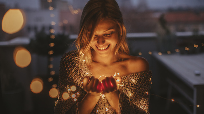 woman holding fairy lights