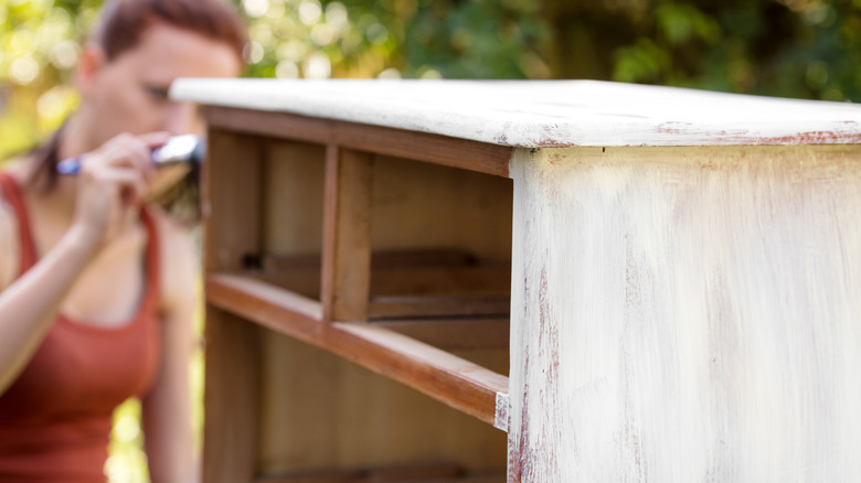 Woman re-finishes her dresser