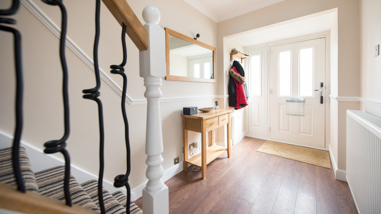 Small home entryway that is brightened by windows in and around the door