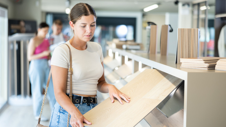 Female shopper touches flooring sample