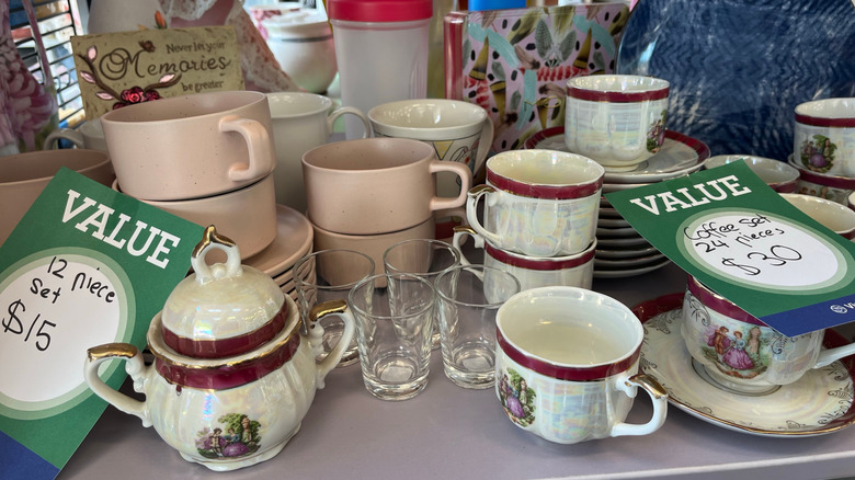 Collection of mugs, glasses, and other dishes at a thrift store