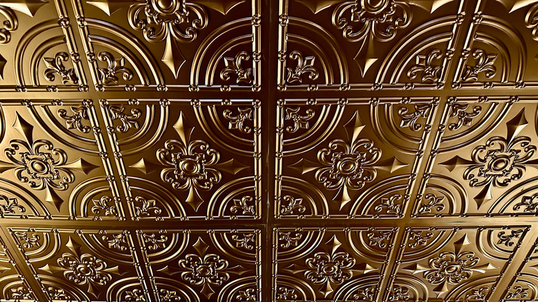 A close-up of metallic tin tiles on a ceiling