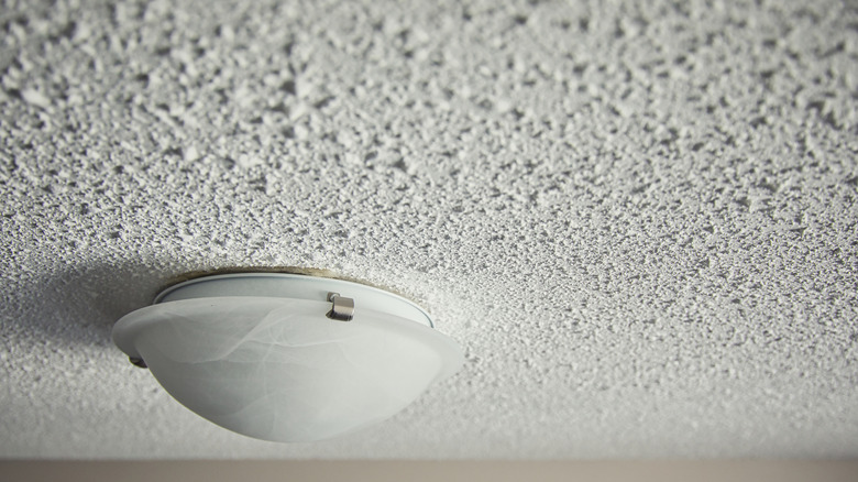 Close-up of a popcorn ceiling with a white light fixture