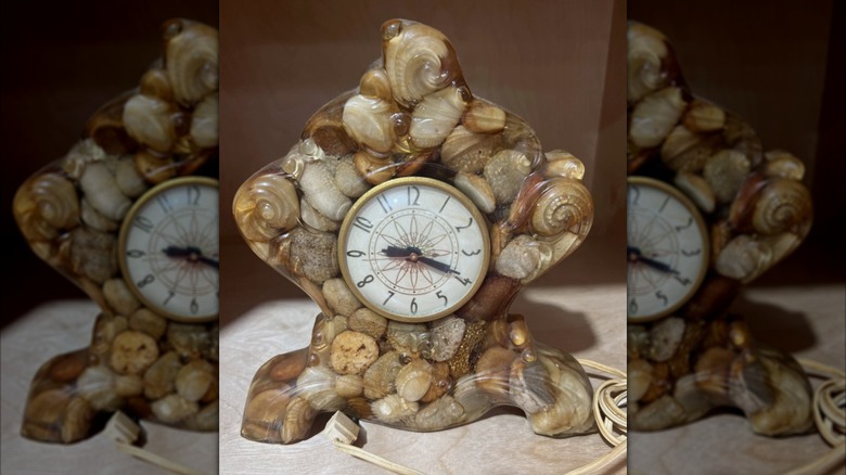 Vintage lanshire vomit clock made with with rocks sitting on table.
