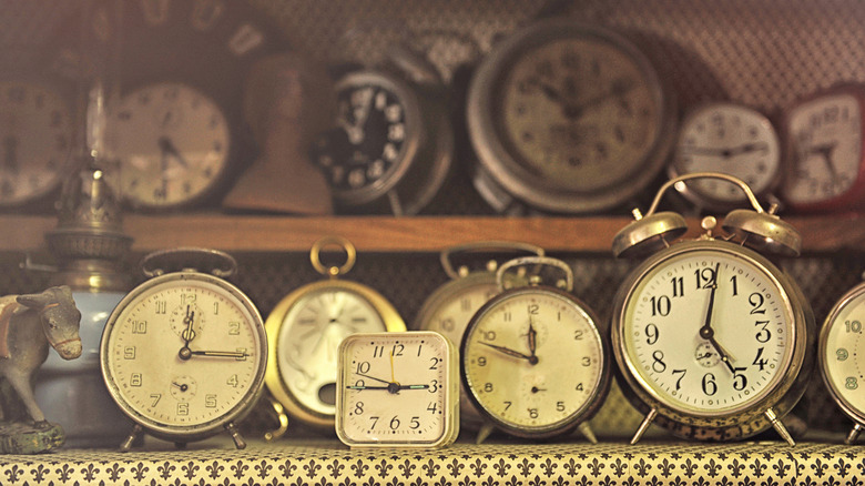 A variety of antique clocks on shelves.