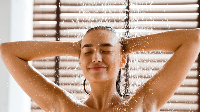 A smiling person enjoying a shower