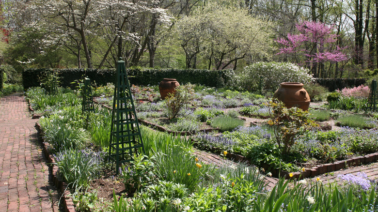 A formal garden with brick walkways and trellises