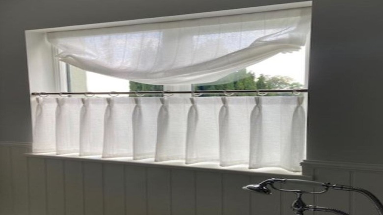 Half Roman shade and half cafe curtain in bathroom window