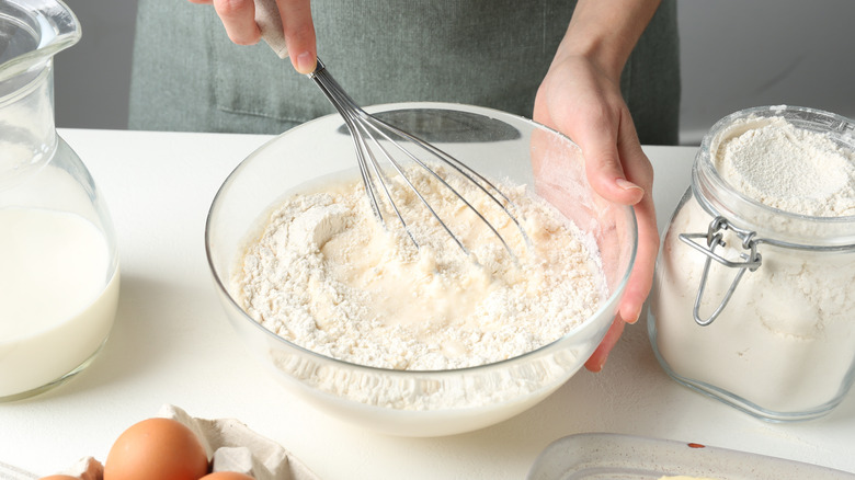 A woman mixing ingredients to make pastry dough