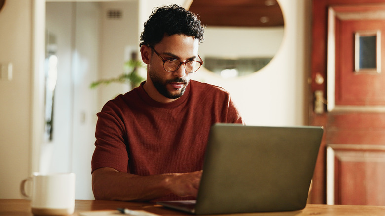 Man working on his laptop while sitting in the living room