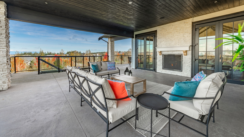 An open air porch with a fireplace and comfortable seating