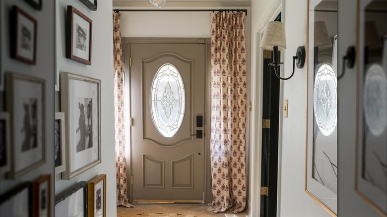 Patterned curtains on black curtain rod over front door