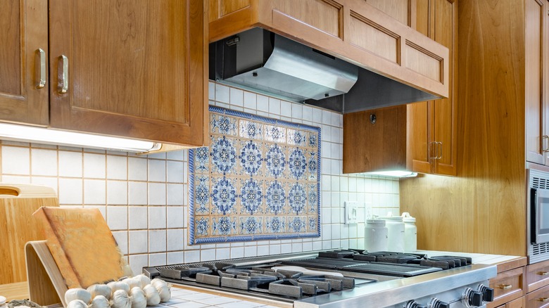 Patterened tile in the center of white tile on kitchen backsplash