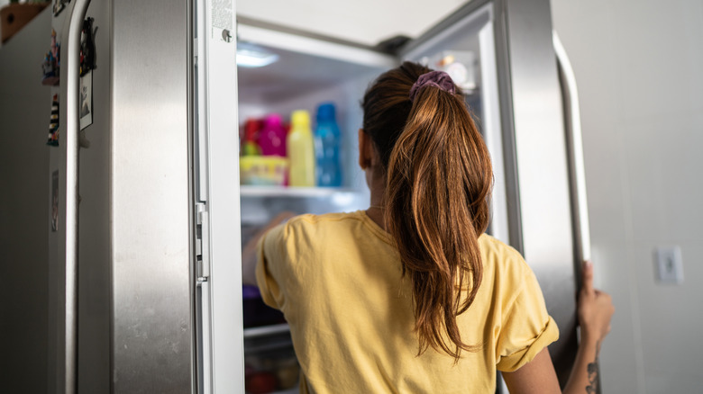 woman getting something from fridge