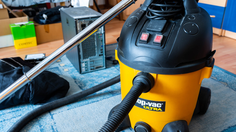 A heavy-duty yellow shop-vac sitting in a garage.