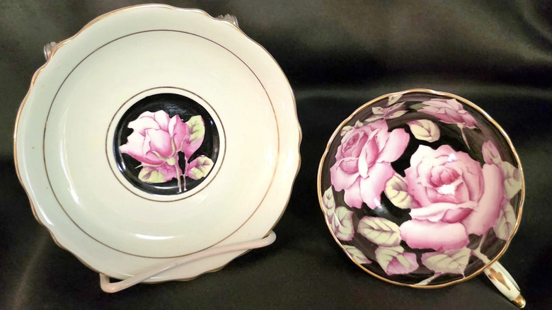 A Paragon China cabbage rose cup and saucer set with a pink and black pattern.