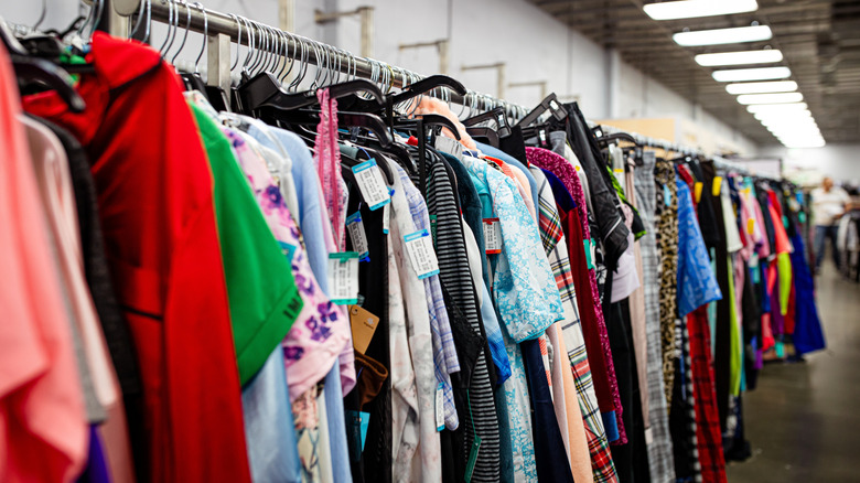 rack of coats and dresses hung inside of thrift store