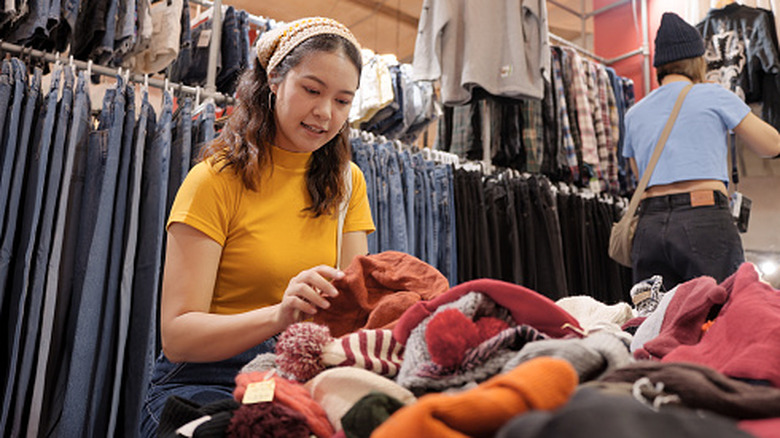 Young woman browsing thrift store items