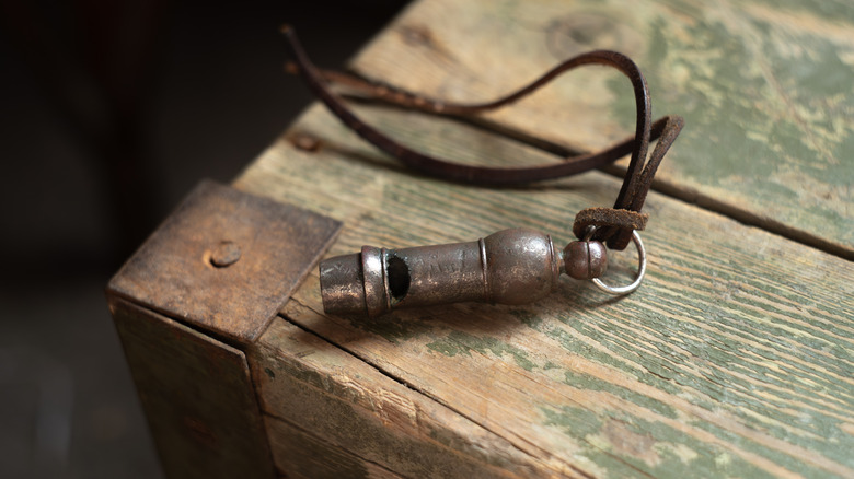 A vintage police whistle on a leather string