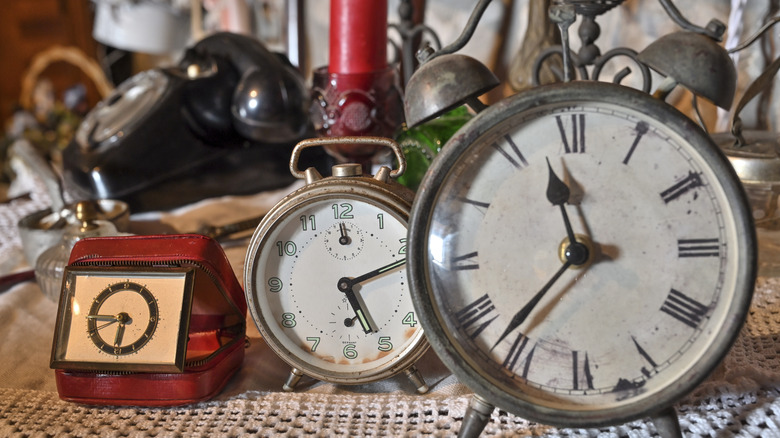 Three antique alarm clocks in a thrift store