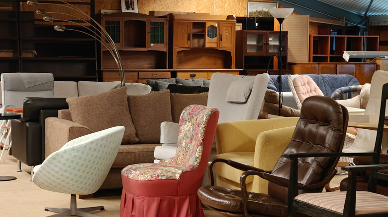 An array of vintage chairs in a thrift shop.