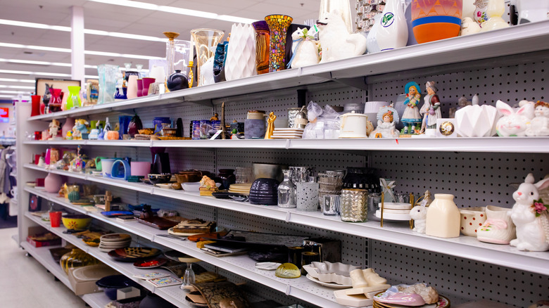 Secondhand houseware items lined up on thrift store shelves
