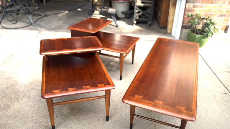 Three restored vintage Lane Furniture Acclaim tables in front of an open garage