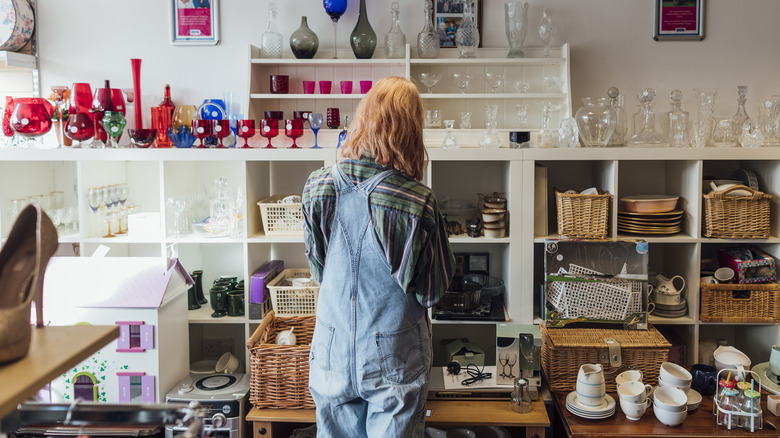 Woman looking at dishware in thrift store