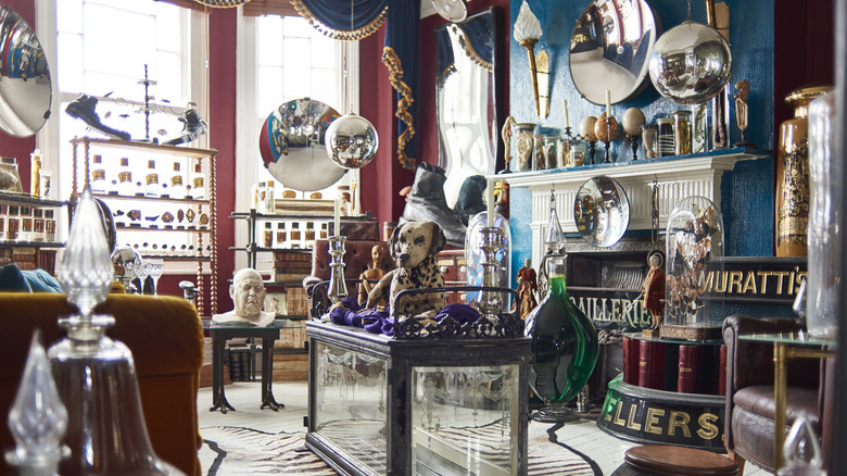 inside of a thrift shop with blue and red walls and antiques on shelves