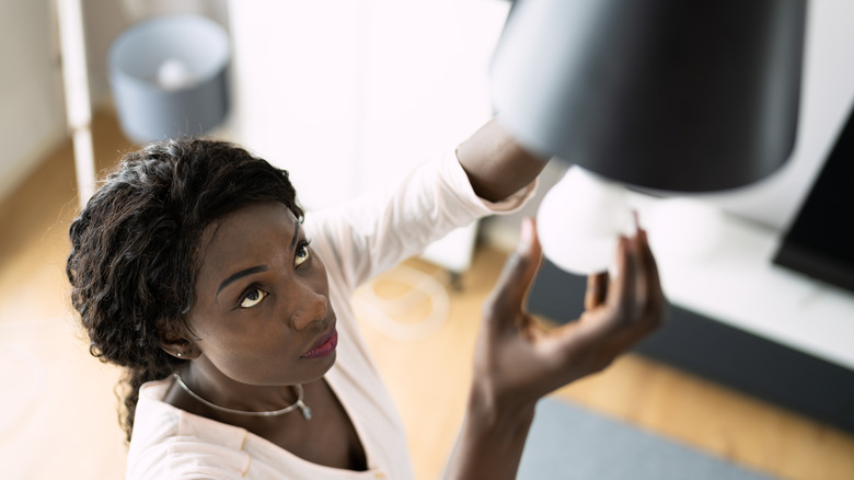 Woman fixing lightbulb