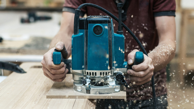 A carpenter using a heavy-duty wood router