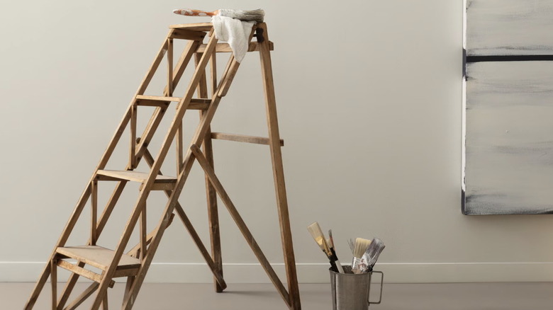 Benjamin Moore's Light Pewter on a wall with painting supplies nearby