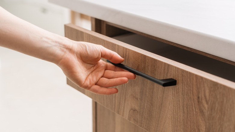 A person opening a drawer