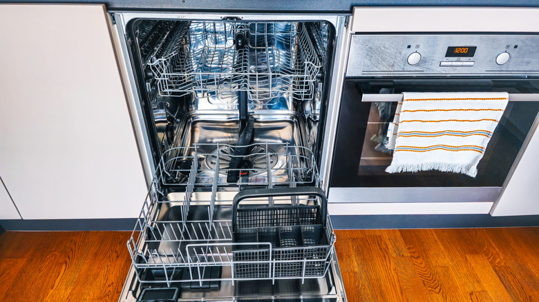 Empty dishwasher left open in kitchen.