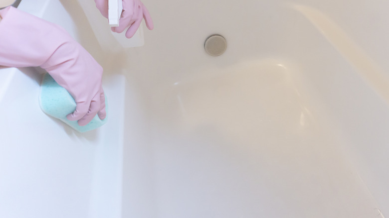 person cleaning a bathtub