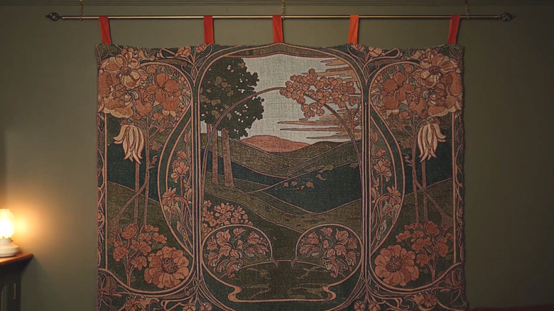 tapestry blanket hanging from curtain rod on wall