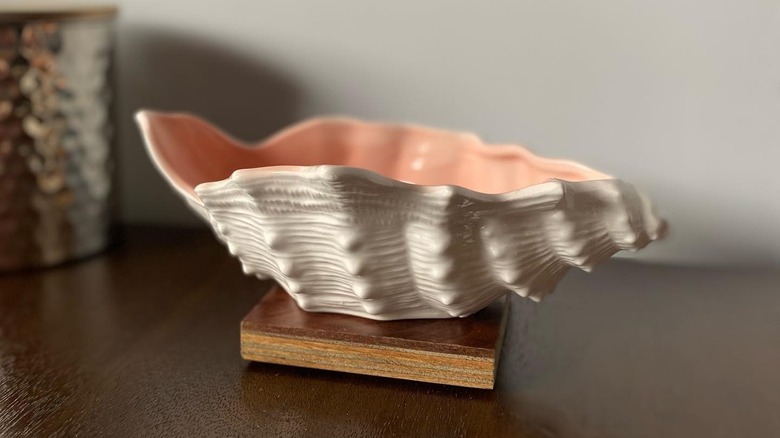 A vintage Fitz and Floyd shell planter with a light piink inside