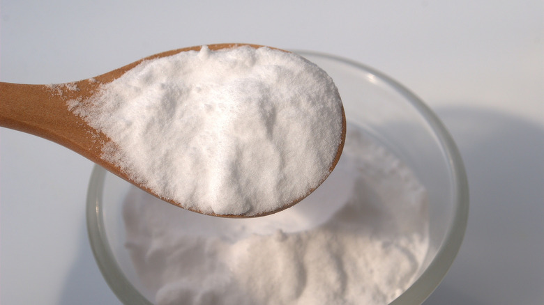 A spoonful of baking soda with a bowl underneath