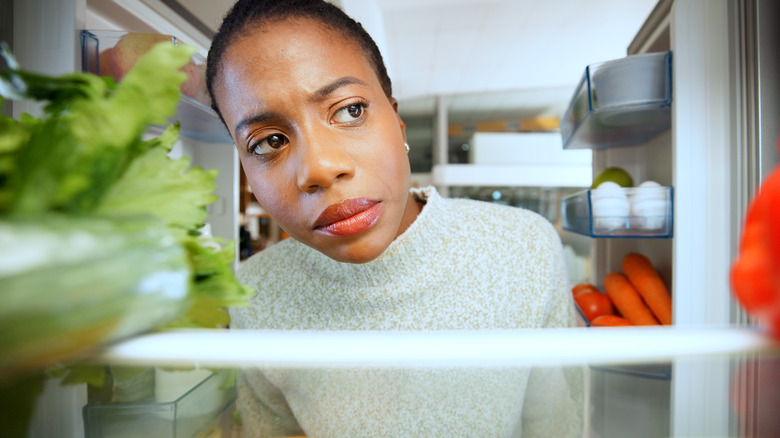 A person peering into the fridge