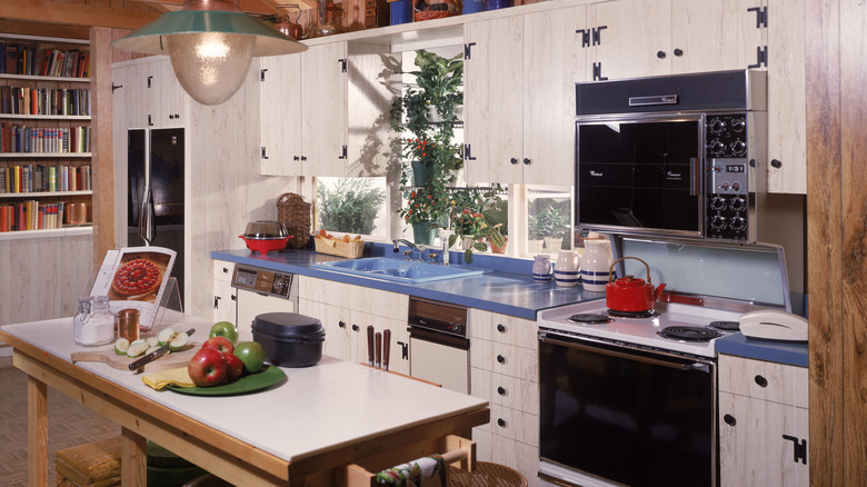 1980s kitchen with white cabinets and blue countertop.