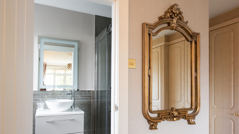 A gold antique mirror in a hallway