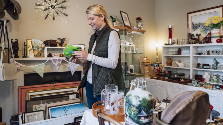 A woman shopping through vintage glass items